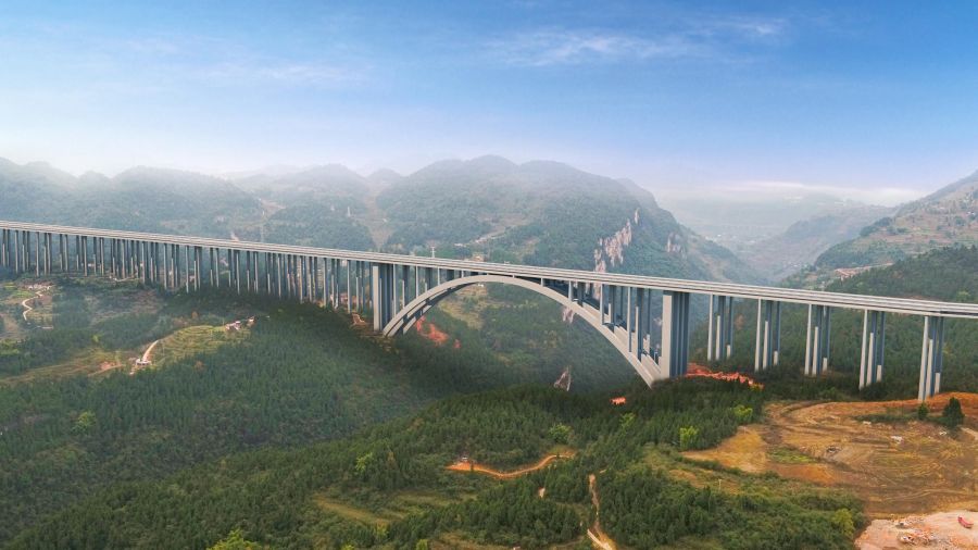 古金高速水落河特大橋，全長1701米，為上承式鋼筋混凝土懸臂澆筑拱橋，跨徑335米，超過世界已知同類型最大跨徑拱橋---美國胡佛水壩大橋332m的跨徑，穩(wěn)居世界第一。該橋首創(chuàng)數(shù)字化智能橋梁建設、管理、施工作業(yè)體系，在結構上為大跨度混凝土拱橋的設計提供基礎和參考，為山區(qū)寬幅薄壁箱型拱橋的懸臂施工提供技術經(jīng)驗。.jpg